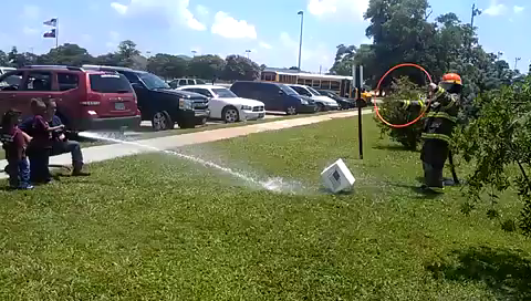 kids spraying a fireman
